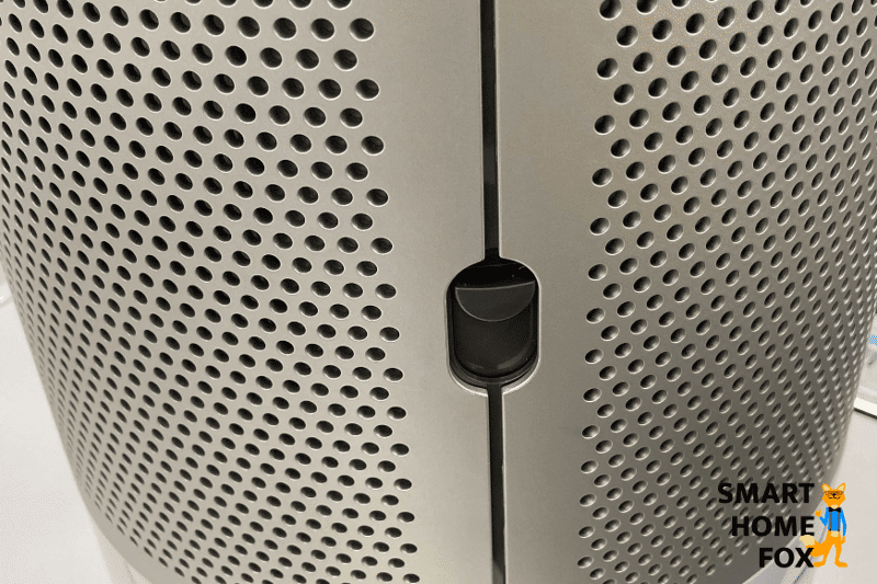 Der Schieberegler an der Seite der Luftgitter vom Dyson Pure Humidify and Cool PH01 wird nach unten gedrückt.